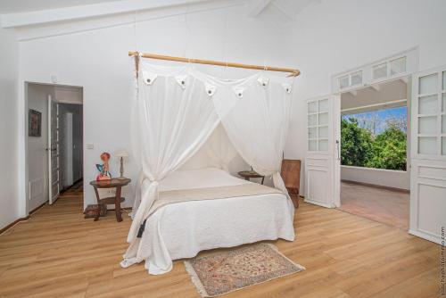 una camera con letto a baldacchino di Villa de caractère vue mer et plantations a Le François
