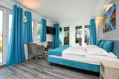 a bedroom with blue curtains and a bed and a desk at City-Hotel Zuffenhausen in Stuttgart