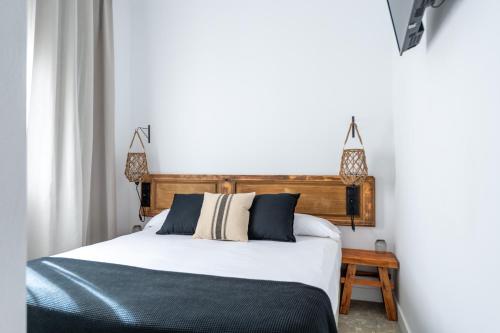 a bedroom with a bed with a wooden headboard at Hostal Boutique Es Menut in Tossa de Mar