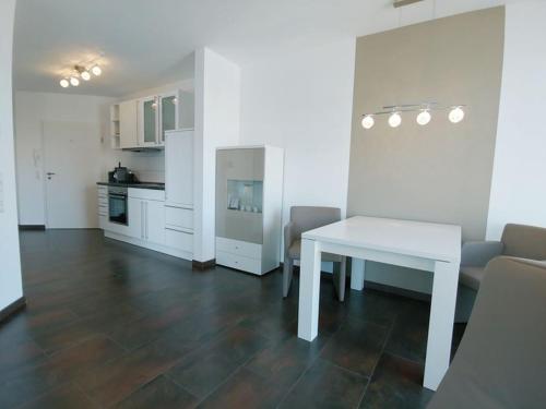 a living room with a white table and a kitchen at Luxury Golf Apartment Bad Bellingen 5-9 in Bad Bellingen