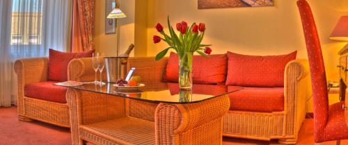 a living room with a couch and a table with flowers at Hotel Kreuzer in Wedel