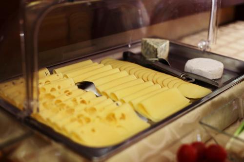 a display of cheese and cheese sticks with a knife at City Hotel Nitra with free parking in Nitra