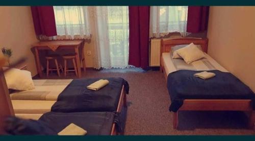 a hotel room with two beds and a piano at Willa nad Potokiem in Zakopane