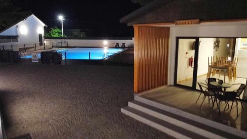 a house with a swimming pool at night at School Motorhome Park in Óvoa