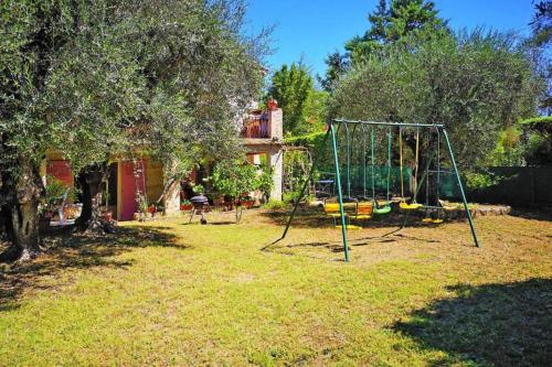 a playground with a swing set in a yard at Ma Vie Là in Fayence