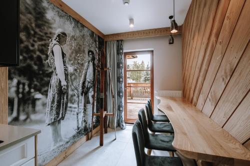 una habitación con 2 sillas y una pared con una pintura en Górskie Szczyty Apart & SPA Apartament 11 Sauna Jacuzzi i Parking w cenie en Zakopane