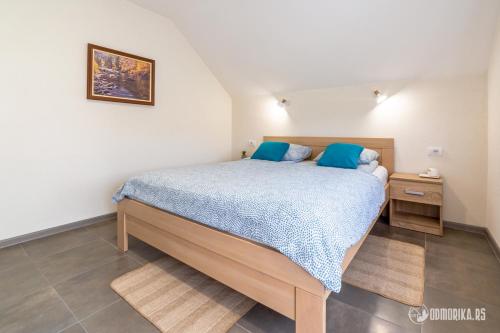 1 dormitorio con 1 cama grande con almohadas azules en MAK BASTA en Bajina Bašta