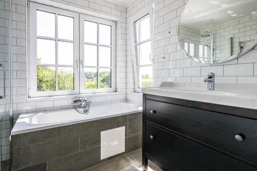 ein Badezimmer mit einem großen Waschbecken und einem Spiegel in der Unterkunft Exclusive tranquil villa by the sea, boat available in Drottningskär