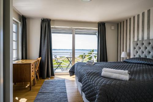 Schlafzimmer mit einem Bett und Meerblick in der Unterkunft Exclusive tranquil villa by the sea, boat available in Drottningskär