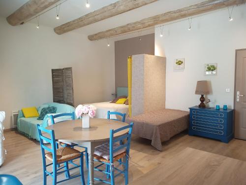 a room with a table and chairs and a bedroom at Gite Le Petit Luberon LISIANTHUS in Cabrières-dʼAvignon