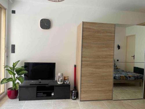 Sala de estar con una gran mampara de madera y TV en Studio avec terrasse au centre de Saint-Tropez, en Saint-Tropez