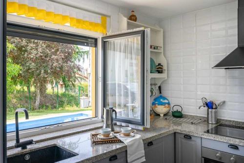 eine Küche mit einem Waschbecken und einem großen Fenster in der Unterkunft Casa Rural en Lucena in Arboleya