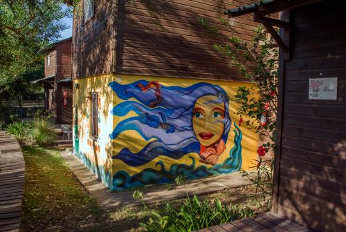 a mural of a woman painted on the side of a building at Cabañas PATALSUELO in Barra de Valizas