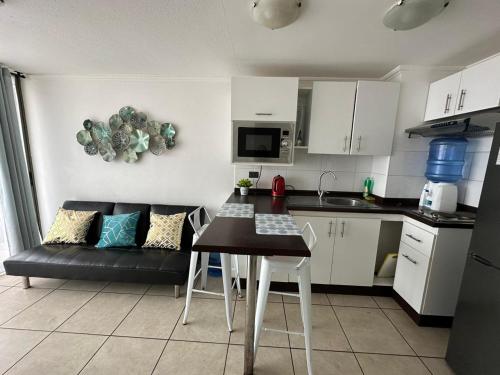 a kitchen with a table and a couch in a room at Departamento NEO IQUIQUE VISTA AL MAR 3 in Iquique