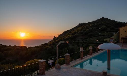 a pool with the sunset in the background at Il Blu Tanca Piras in Nebida