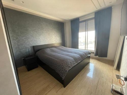 a bedroom with a bed and a large window at APPARTEMENT HAUT STANDING proche gare casa voyageur in Casablanca