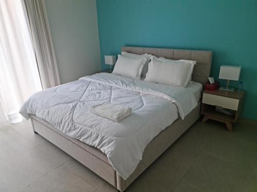 a bedroom with a large bed with a blue wall at Beautiful 1 Bedroom at Soho Square at Al Saadiyat Island in Abu Dhabi