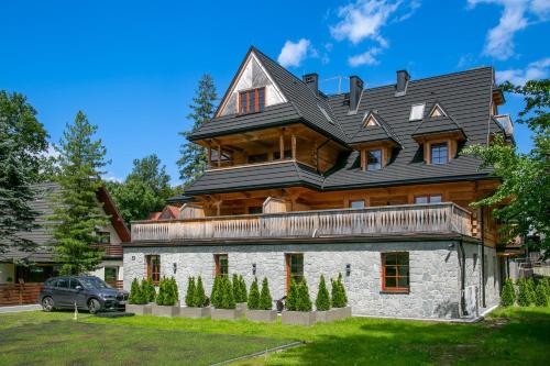 a large house with a gambrel roof at Górskie Szczyty Apart & SPA Hawrań Sauna Jacuzzi i Parking w cenie in Zakopane