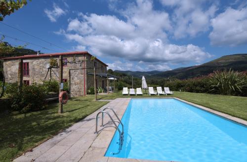 a pool in front of a house with a building at Casa férias, piscina, Ponte de Lima in Ponte de Lima