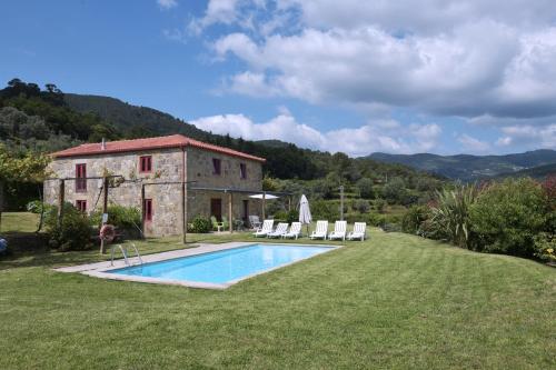 an old building with a swimming pool in a yard at Casa férias, piscina, Ponte de Lima in Ponte de Lima
