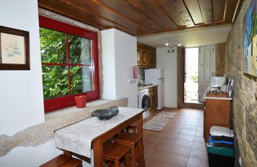 a kitchen with a table and a window in a room at Casa férias, piscina, Ponte de Lima in Ponte de Lima