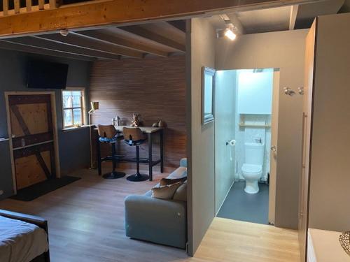 a room with a bed and a bathroom with a toilet at Shed 100 in Westerlee