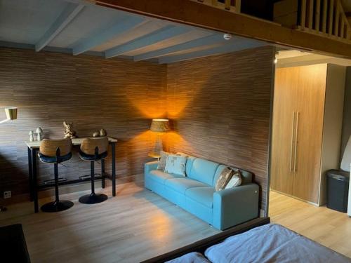 ein Wohnzimmer mit einem blauen Sofa und einem Tisch in der Unterkunft Shed 100 in Westerlee