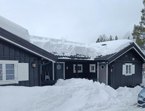 une maison noire avec de la neige sur le toit dans l'établissement Baybu - cabin close Geilo Skisenter and the center of Geilo, à Geilo