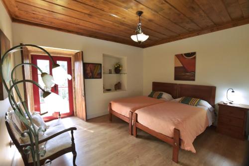 a bedroom with a bed and a chair in it at Casa férias, piscina, Ponte de Lima in Ponte de Lima