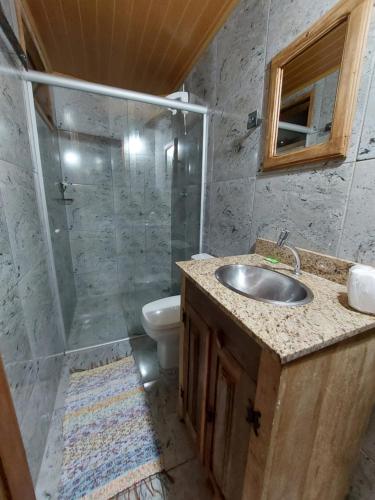 a bathroom with a shower and a sink and a toilet at Astral de Minas in Tiradentes