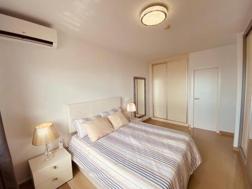 ein Schlafzimmer mit einem Bett und einer Lampe auf einem Nachttisch in der Unterkunft Gold Sunset in Adeje