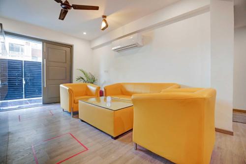 - un salon avec des chaises orange et une table dans l'établissement Townhouse HOTEL CLOUD BAY, à Gurgaon