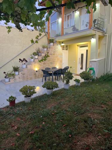 a patio with a table and chairs in front of a house at CARA Creta Home in Kolymvari
