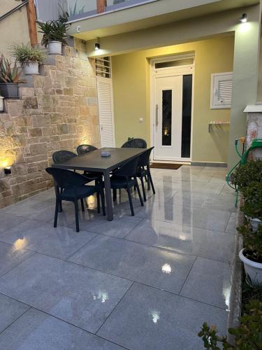 a patio with a table and chairs on a patio at CARA Creta Home in Kolymvari