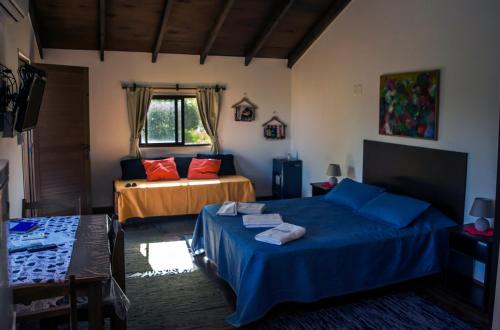 a bedroom with two beds with blue sheets and red pillows at Cabañas PATALSUELO in Barra de Valizas