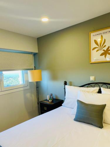 una camera da letto con un grande letto bianco e una finestra di Iris Luxury House ad Ágioi Déka