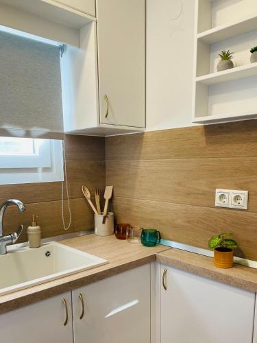 uma cozinha com armários brancos e um lavatório em Iris Luxury House em Áyioi Dhéka