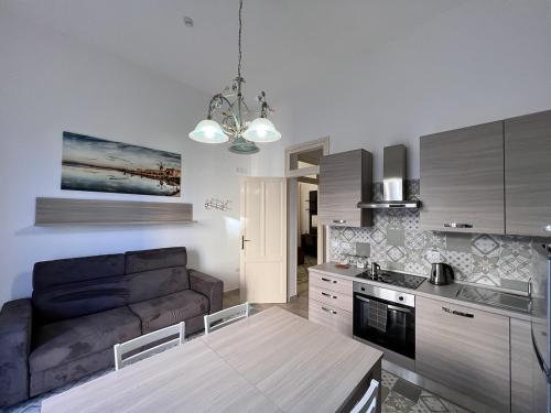 a kitchen and living room with a couch and a table at Osorio 74 Apartments in Trapani