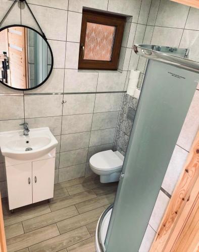 a bathroom with a toilet and a sink and a mirror at Domki u strażaka in Jastarnia