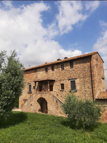 an old brick building with an archway in a field at Casa Zeno in Volterra