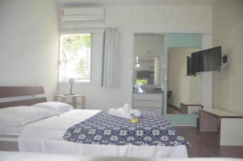 um quarto de hotel com uma cama com uma toalha em Hospedagem Praia de Piratininga em Niterói