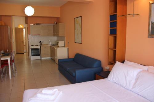 a bedroom with a bed and a couch and a kitchen at Captain's Lodge in Ermoupoli
