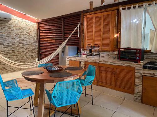 a kitchen with a wooden table and blue chairs at Casa Maya Xul-Ha in Xul-Ha