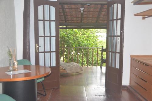 um quarto com uma mesa e uma varanda em Hospedagem Praia de Piratininga em Niterói