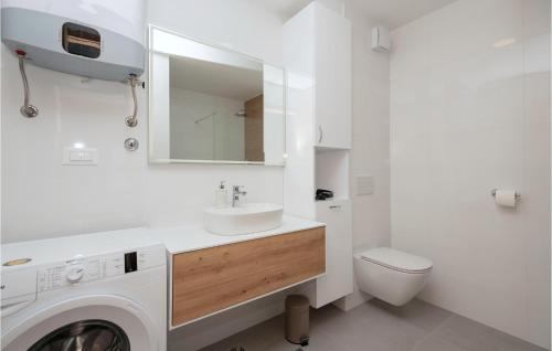La salle de bains blanche est pourvue d'un lavabo et d'un lave-linge. dans l'établissement Gorgeous Apartment In Makarska With Wifi, à Makarska