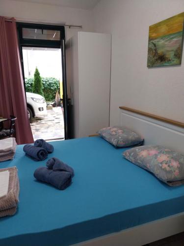 1 Schlafzimmer mit 2 Kissen auf einem blauen Bett in der Unterkunft Sobe Kraft 1 in Živogošće