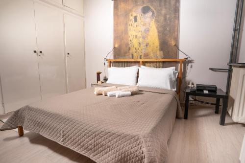 a bedroom with a large bed with a painting on the wall at Angel Apartment in Athens