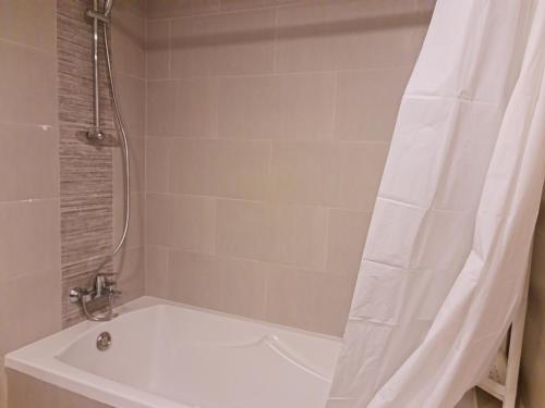bagno con vasca e doccia con tenda. di Beautiful 1 Bedroom at Soho Square at Al Saadiyat Island a Abu Dhabi