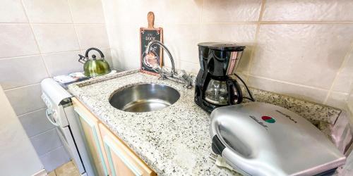 eine Küchentheke mit einem Mixer und einem Waschbecken in der Unterkunft Requinte e Sofisticação - Monte Belo Flat in Gramado