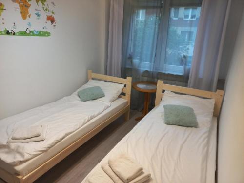 - 2 lits dans une petite chambre avec fenêtre dans l'établissement Mieszkanie 3 pokojowe Park Chopina, à Świnoujście